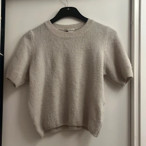 Beige kort armada stickad tröja från Chelsea - Säljer en mysig beige stickad tröja från Chelsea. Tröjan har korta ärmar och en rund halsringning. Perfekt för en stilren och bekväm look. Passar bra till både jeans och kjol. Helt ny. Storlek XS-S 💗💗