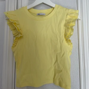 Gul ribbad topp från Zara - Säljer en söt gul ribbad topp från Zara med volanger vid ärmarna. Oanvänd i storlek M💕