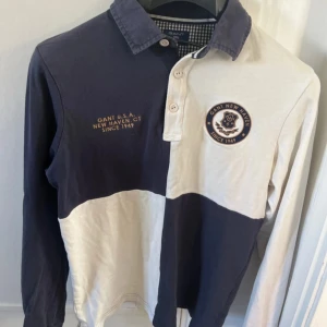 Rutig rugby polo pikétröja från GANT i blått och vitt strl S - Säljer en stilren pikétröja från GANT i storlek S. Klassisk krage med knappar och rutigt foder på insidan av kragen. Perfekt för dig som gillar preppy stil. Storlek S inköpt för 1699 på NK för ett par år sedan