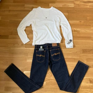 Nudie Jeans blå jeans W28 L34 - Tjena säljer nu nästan helt oanvända Nudie Jeans i storlek 28/34 slim fit. Jag passade inte riktigt i dom här jeansen så jag tänker att jag säljer dom istället.   dom här jeansen är de finaste Nudie jeansen på hela plick, dessutom till bästa pris. Det är bara att fråga på med frågor eftersom jag är inne dagligen och jag kan också skicka fler bilder om det behövs. Ps det är bara jeansen som medföljer inget annat klädesplagg  på första bilden. Kommer hem den 2025-08-13 så då fraktar jag 
