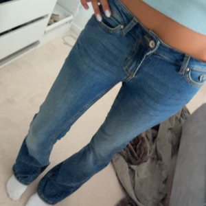 Blå bootcut jeans med låg midja - Säljer ett par snygga blå jeans med bootcut-modell och låg midja. Min spegel som är smuttsig inte jeansen! 