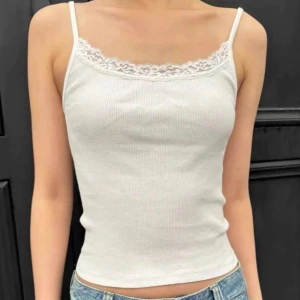 Brandy topp - Säljer en vit ribbad BrandyMelville topp med smala axelband och fin spetskant upptill. Toppen är ärmlös och har en enkel, clean look som passar perfekt till jeans eller kjol. Materialet känns mjukt och stretchigt.