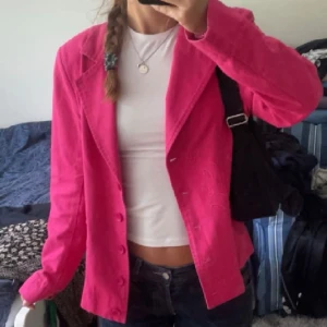 Rosa kavaj / jacka från Westerlind med broderi - Snygg rosa kavaj från Westerlind med blommigt broderi på ena sidan. Jackan har klassisk krage, knappar framtill och är tillverkad i ett bomullsliknande material. Perfekt för dig som vill sticka ut med färg och detaljer.