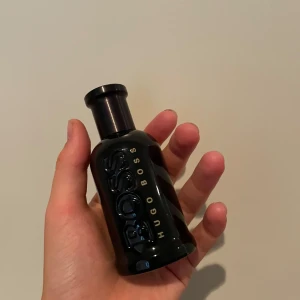Hugo Boss-EAU de parfyme - Snygg parfymflaska från Hugo Boss i svart glas med tydlig BOSS-logga. Doften känns lyxig, moder och väldigt manlig. Perfekt för dig som gillar eleganta och maskulina dofter. Flaskan kostar runt 1100 kr ny. Cirka 75 ml/100 ml. 