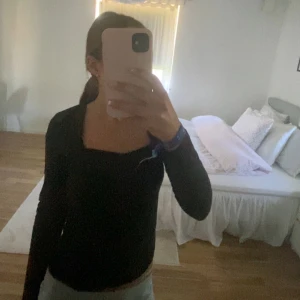 Svart u-ringad långärmad - Svart urringad långärmad tröja från H&M i strl S. Vita fläckar där nere som syns på bilden.