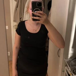 Svart t-shirt  - En enkel och stilren svart t-shirt från lager 157 med rund halsringning och korta ärmar. T-shirten är gjord i mjuk bomull och har en figurnära passform som framhäver siluetten. Perfekt för dig som gillar minimalistisk stil.