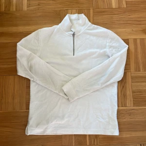 Vit half zip polotröja Jack & Jones - Snygg vit polotröja från Jack & Jones Premium i storlek M. Tröjan har en stilren half zip-dragkedja framtill och långärmad design. Materialet är mjukt och känns som bomull, perfekt för lager-på-lager. Passar dig som gillar cleana och enkla plagg med modern touch.