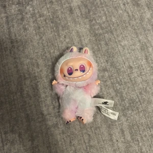 Labubu - Hej jag säljer en äkta labubu man ser på etiketten att den är äkta med qr koden. Vill göra av med den så fort som möjligt. Den kosta 1200sek fast säljer den för 250. Jag köpte den idag också det är nytt skick har bara tagit ut den ur boxen. Labubun är (Luck)