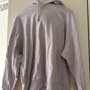 Ljuslila hoodie från 157 - Säljer en chill ljuslila hoodie från 157 med huva och snörning. Tröjan är i mjuk bomull och har långa ärmar samt ribbade muddar vid ärmslut och nederkant. Perfekt för att slänga på sig när man vill vara bekväm och ändå se snygg ut.