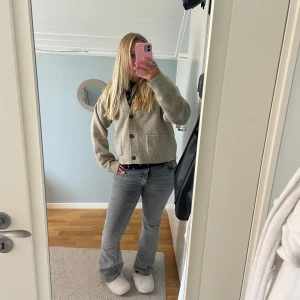 Grå bootcut jeans från Perfect Jeans - Säljer ett par grå jeans från Perfect Jeans i modell bootcut. Jeansen har klassisk femficksdesign, normal passform och är tillverkade i mjukt denimtyg. Snygg tvättad grå färg som passar till allt och midja med knapp och dragkedja.