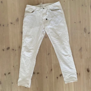 Vita byxor från Massimo Dutti, strl 44 - Snygga vita byxor från Massimo Dutti i storlek 44. De har dragsko i midjan, raka ben och flera fickor både fram och bak. Byxorna är gjorda i ett lätt bomullstyg som passar perfekt till varmare dagar. Stilren och fräsch look.