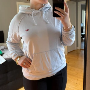 Ljusblå hoodie från Levis - Ljusblå hoodie i storlek S i fint skick från Levis. Den har några få blekningsfläckar vid muddarna i händerna men annars jättefin.