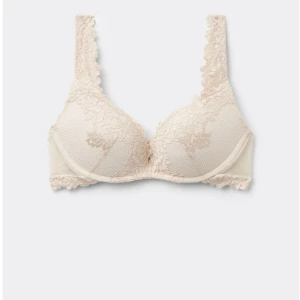 Beige spetsig bh-topp - Säljer en beige bh-topp med vacker spets och breda axelband. Toppen har fina spetsdetaljer längs kanterna och en mjuk, feminin look. Perfekt för dig som gillar romantiska och stilrena underkläder. Nypris 599kr