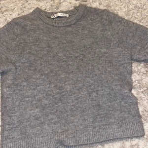 Grå stickad t-shirt från zara - Jätte fin tröja i storlek S, säljs pågrund av att den inte kommer till användning. Den är i bra stick💓