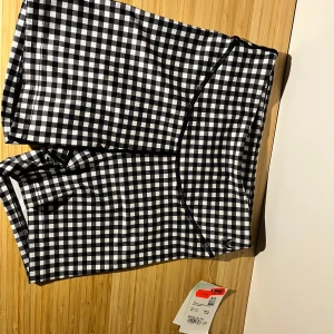 Svarta och vita rutiga shorts från SOC - Rutiga shorts från SOC i svart och vitt, med elastisk midja, prislapp kvar och säljer för samma pris