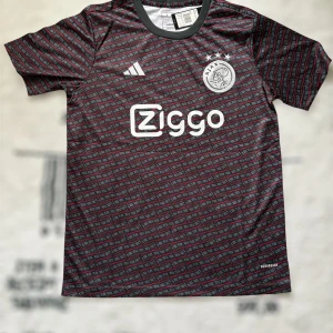 Ajax Amsterdam x Adidas fotbollströja - Ajax Amsterdam fotbollströja från Adidas med grå och svarta toner, röda detaljer och ett unikt mönster över hela tröjan. Broderat Ajax-märke på bröstet, Ziggo-logga och klassisk rund hals. Tillverkad i lätt och ventilerande material, perfekt för match eller träning.