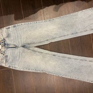 Ljusblå raka jeans från Kappahl - Säljer ett par ljusblå jeans från Kappahl i rak modell. Jeansen har klassisk femficksdesign med snygga ficklock och knapp bak, samt bälteshällor. Tillverkade i jeansmaterial med kontrastsömmar. Perfekta för en chill och stilren look.