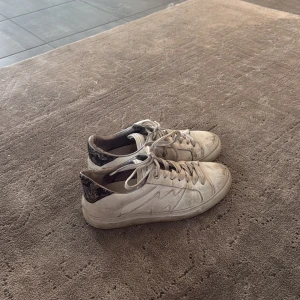 Vit sneakers Zadig & Voltaire - Säljer ett par vita sneakers från Zadig & Voltaire med cool blixtdetalj på sidan och svart mönstrad häl. Skorna har snörning och platt sula, tillverkade i skinn. Dom ör väl använda men fortfarande väldigt snygga men är tyvärr för små för mig💗 jag tvättar dom innan jag postar 💗 priset kan diskutrrassss