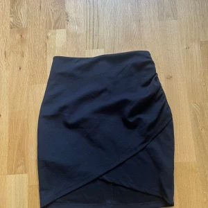 Supersnygg svart omlott kjol ifrån bikbok - En jättefin svart omlottklännings ifrån bikbok i storlek xs. Högmidjad men har man en tröja över blir det en superfin kort kjol som passar till mycket! Säljes eftersom den ej passar längre 💓💓