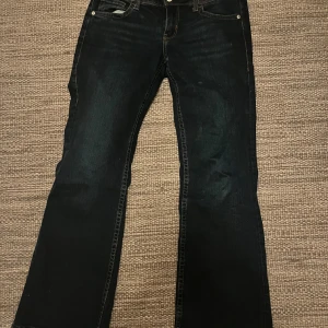 Mörkblå bootcut Divided - Säljer ett par jeans då ja har två likadana! De är sprättade längs ner så de blir lite längre smaksak om d men inget märkbart💕 Storlek ser man på bilden S/M