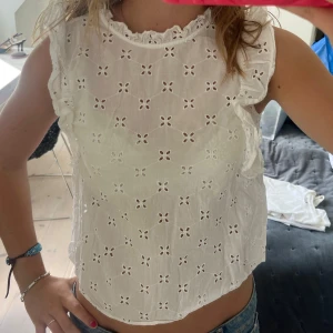 Vit blus med broderade blommor - Supersöt vit blus i bomull med broderade blommor och små hål, volangdetaljer, så fin!!