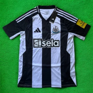 Newcastle Isak 14 Adidas matchtröja - Newcastle Uniteds officiella matchtröja från Adidas med Isak 14-tryck på ryggen. Klassisk svartvit randig design, kortärmad med gula detaljer på ärmen och klubbmärke på bröstet. Tillverkad i lätt och ventilerande material för maximal komfort.