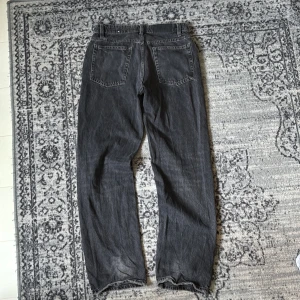 Svarta baggy jeans från Zara - Säljer ett par svarta jeans från Zara med rak passform och klassisk femficksdesign. Jeansen har knappgylf och är tillverkade i slitstarkt denimtyg. Perfekta för dig som gillar en enkel och clean look. storlek w28 