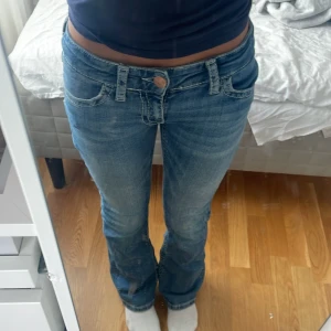 Blå bootcut jeans från Gina Tricot - Säljer ett par snygga blå jeans från Gina Tricot i storlek 152. Modellen har bootcut-ben, låg midja och coola detaljer med kontrastsömmar på bakfickorna. Klassisk femficksdesign och tillverkade i mjukt denimtyg. Perfekt för dig som gillar retrovibe och bekväm passform. !! Framifrån ser den ksk lite skinni ut men det är som sakt för den är för liten!! Diskuterar pris 💕