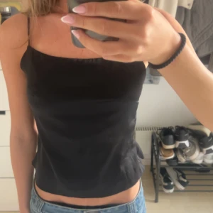 Svart satin topp med öppen rygg - Säljer denna jätte snygga svarta satin topp med öppen rygg!! Köpte den utomlands!!🤍🤍