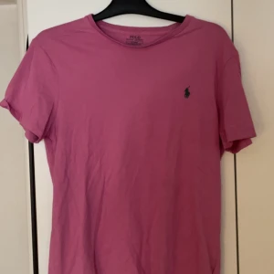 Rosa t-shirt Polo Ralph Lauren - Snygg rosa t-shirt från Polo Ralph Lauren i slim fit-modell. Klassisk design med korta ärmar. Säljer den pga den är för stor för mig, jag har strl xs/s och detta är en strl m som lutar mer åt L hållet. Aldrig använd 💞
