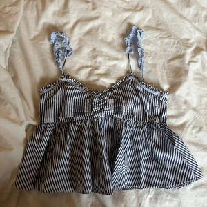 Randig volangtop från Zara  - Supersöt topp från Zara med smala blå och vita ränder, volangdetaljer och rynkade axelband. Säljs inte längre! Skriv om ni har några frågor!💞