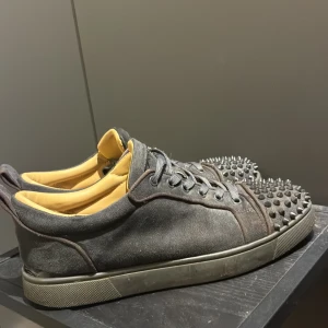 Christian Louboutin grå sneakers med nitar - Säljer ett par grymma grå sneakers från Christian Louboutin med nitar på tån och klassisk röd sula. De ända är att de saknas 1 nit som man ser tydligt på bild 3. annars får ni avgöra själva utifrån bilderna. Pris kan diskuteras 