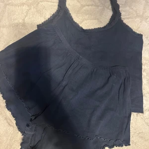 Mörkblå ribbad linnetopp med spets - Supersöt mörkblått sett med linne och shorts med spetsdetaljer längs kanterna. Toppen har ett ribbat mönster och är croppad i modellen.