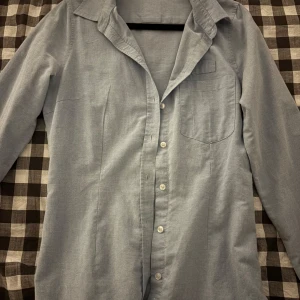 Ljusblå skjorta med klassisk krage - Snygg ljusblå skjorta med klassisk krage och knappar framtill. 