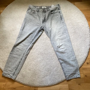 Grå PB jeans - Ljusgråa Pull and Bear jeans enbart använda några få gånger. Modell: Standard Storlek: Eur 44 (Motsvarar ungefär W34/L32) 