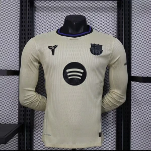 Beige långärmad FC Barcelona tröja - Snygg beige långärmad FC Barcelona fotbollströja från Nike med svarta detaljer och lila inslag på krage och muddar. Tröjan har klubbmärke, Spotify-logga och UNHCR-tryck. Tillverkad i lätt och ventilerande material, perfekt för match eller träning.