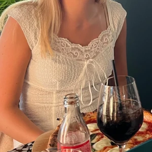 Vit blus med spets och knyt - Jättefin räfflad topp med spets och knyte! Lite korsett detaljer i midjan som gör den väldigt fin