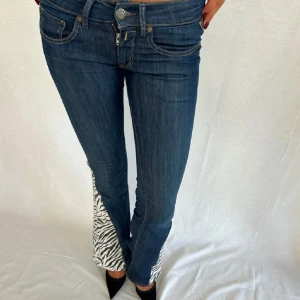 Lågmidjade bootcut jeans - Lågmidjade bootcut jeans från Replay med zebra i sidan. Storlek 26/32. Midjemått rakt över 35 cm. Innerbenslängd 82 cm