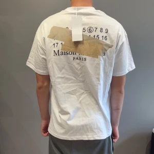 Maison margiela T-shirt  - Säljer en riktigt fet och populär Maison margielas T-shirt. Storlek M, kan även passa L. Han på bild är 185cm, 74kg! Hör av er vid funderingar 