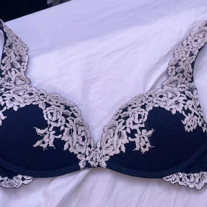 Intimissmi bh - Supersnygg mörkblå bh med ljus spets och broderade blommor längs kanterna och axelbanden. Ingen lapp men strl 70b