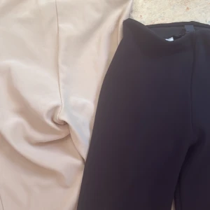 Svarta bootcut kostymbyxor - Snygga svarta kostymbyxor med bootcut passform som ger en trendig siluett. Byxorna har en klassisk midja och är tillverkade i ett mjukt material som känns bekvämt hela dagen. Perfekta för dig som vill ha en stilren look med lite extra edge. Du får med st byxor för 250kr beige och svart 