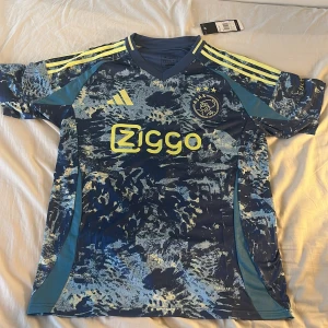 Blå custom Ajax fotbollströja från adidas - Blå adidas fotbollströja med Ajax som logga. Bekväm och färglad. Perfekta tröjan inför sommaren. Helt oanvänd och ren. STORLEK M. PRISET KAN DISKUTERAS.