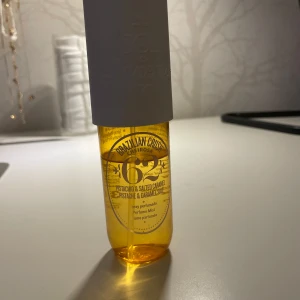 Parfymmist Brazilian Crush Cheirosa 62 - Säljer en härlig parfymmist från Sol de Janeiro, Brazilian Crush Cheirosa 62. Doften har noter av pistage och saltad karamell. Flaskan är genomskinlig med en vit kork och rymmer en gyllene vätska. Perfekt för att fräscha upp din dag med en söt och krämig doft. Observera att flaskan är använd och hälften av parfymen finns kvar. Det är även en lite skavank på parfymens kork men annars är den i gott skick💕💕💕