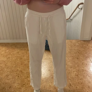 Vita linnebyxor - Säljer ett par vita byxor med snöre i midjan. Byxorna har en loose passform och är tillverkade i ett lätt och bekvämt material, perfekt för en avslappnad stil.