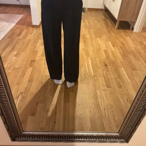 Svarta kostymbyxor - Eleganta mörkblå kostymbyxor med låg midja och rak passform. Perfekta för en stilren look.