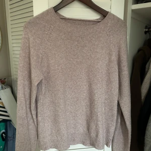 Lila stickad tröja från Vero Moda - Mysig lila stickad tröja från Vero Moda. Perfekt för kyliga dagar med sin mjuka och bekväma passform. Tröjan har långa ärmar och ribbade kanter vid hals, ärmslut och nederkant.