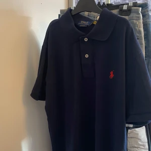 Mörkblå pikétröja från Ralph Lauren - Säljer en stilren mörkblå pikétröja från Ralph Lauren i storlek M. Är i mycket bra skick.