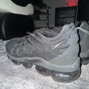 Svarta Nike Vapormax sneakers - Säljer ett par svarta Nike Vapormax sneakers med snörning och en unik bubbelsula. Perfekta för en sportig look och bekväma att bära hela dagen.  8/10 skick! Pris kan alltid diskuteras