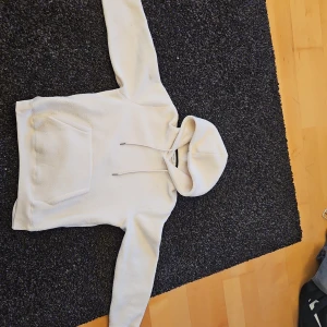 Vit fleece hoodie från Only & Sons - Säljer en mysig vit fleece hoodie från Only & Sons. Den har en stor ficka framtill och en justerbar huva med snören.