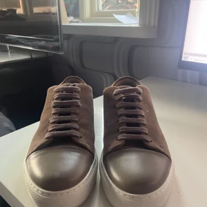 Bruna sneakers från Axel Arigato - Snygga bruna sneakers från Axel Arigato i mocka med vit sula. De liknar lanvins extremt mycket som är extra trendigt just nu och Axel-Arigato är även ett väl respekterat märke nu och extremt populärt. Extremt bra skick och nypris runt 2750 för dessa. OBS priset kan diskuteras vid snabb affär.